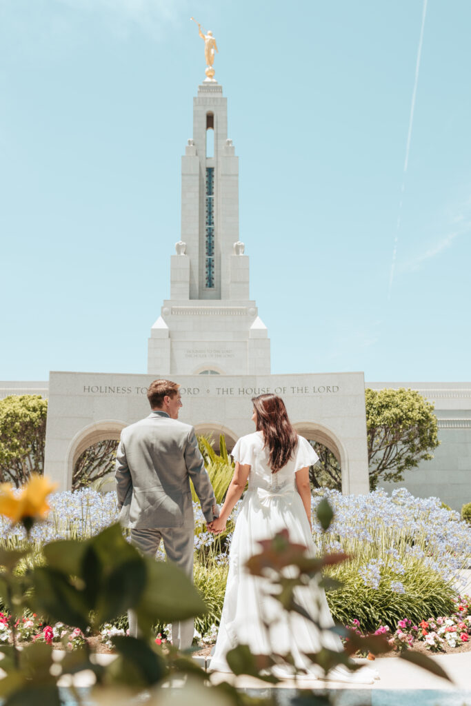 Couple stands outside the Redlands LDS temple on their wedding day.