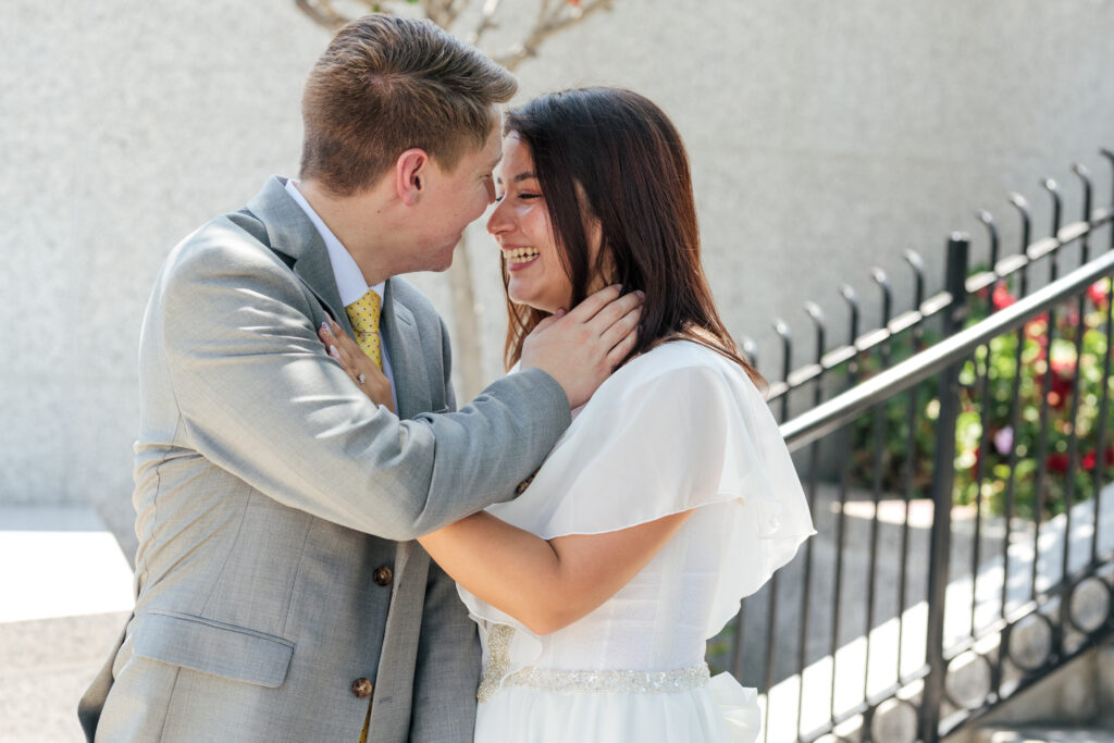 Candid moments of a bride and groom smiling outside the Redlands California LDS temple on their wedding day.