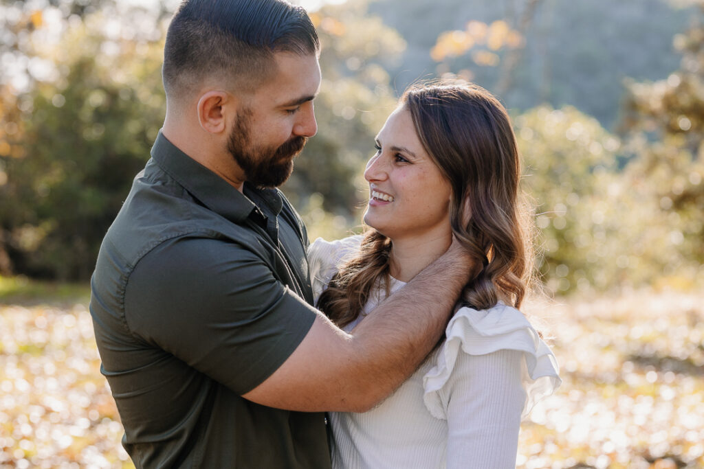 Couple smiling at each other in Oak Glen, CA for photoshoot. 