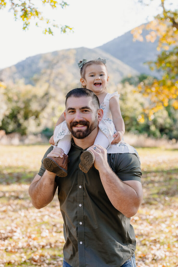 Dad and daughter smiling in Oak Glen, CA for photoshoot. 