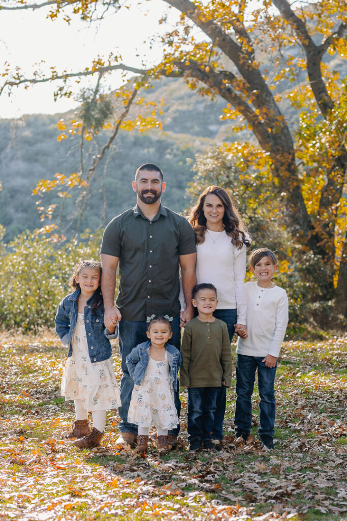 Family smiling in Oak Glen, CA for photoshoot. 